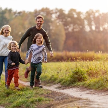 Identity Guard Family Plans identity theft protection service happy family with two children outdoor in nature sunny day